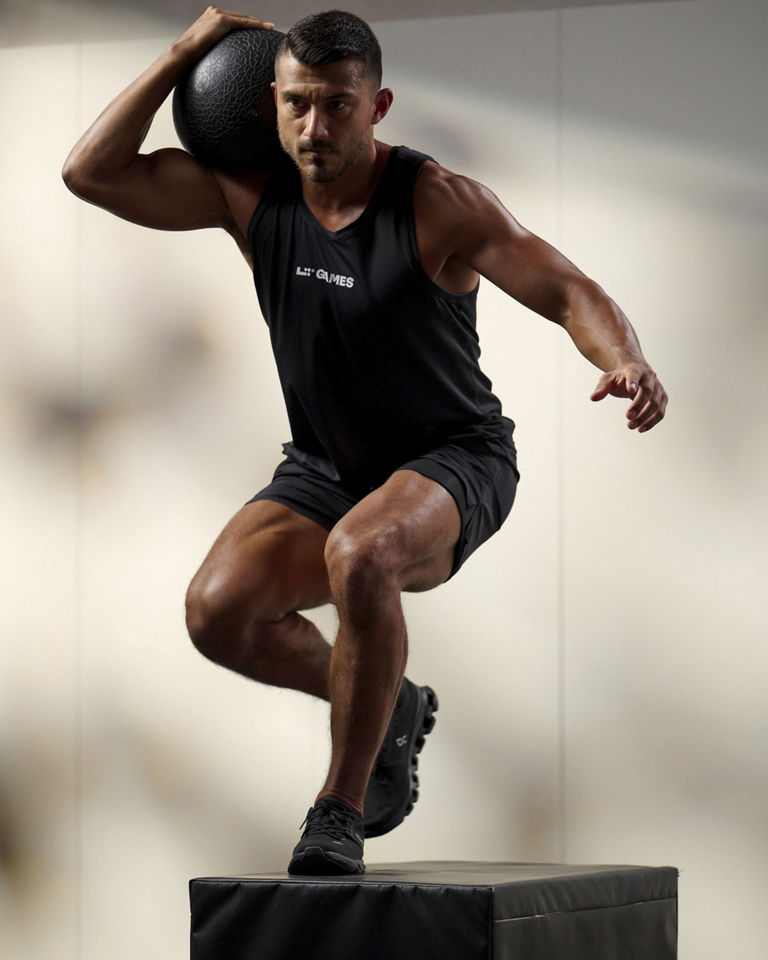 a man doing a box step over with medicine ball