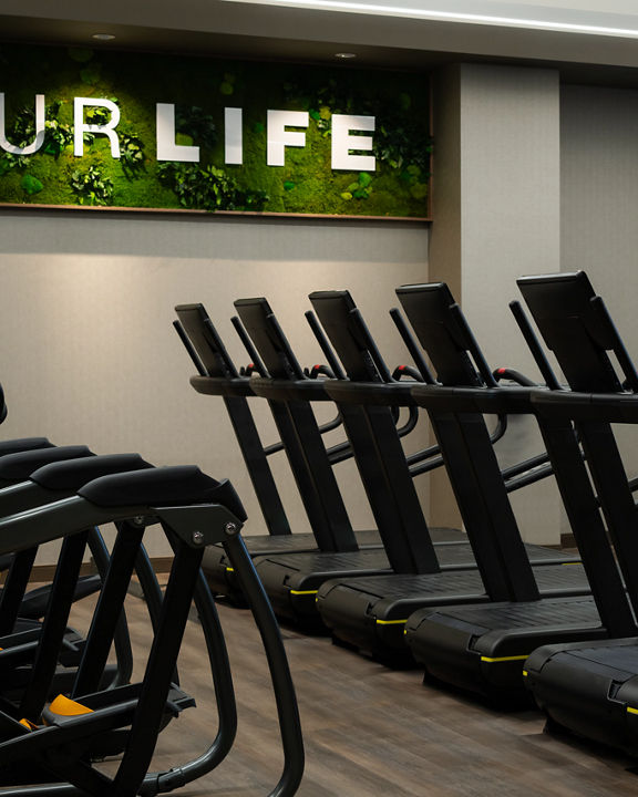 Row of treadmills on the fitness floor at the Life Time Atlantic Avenue club location