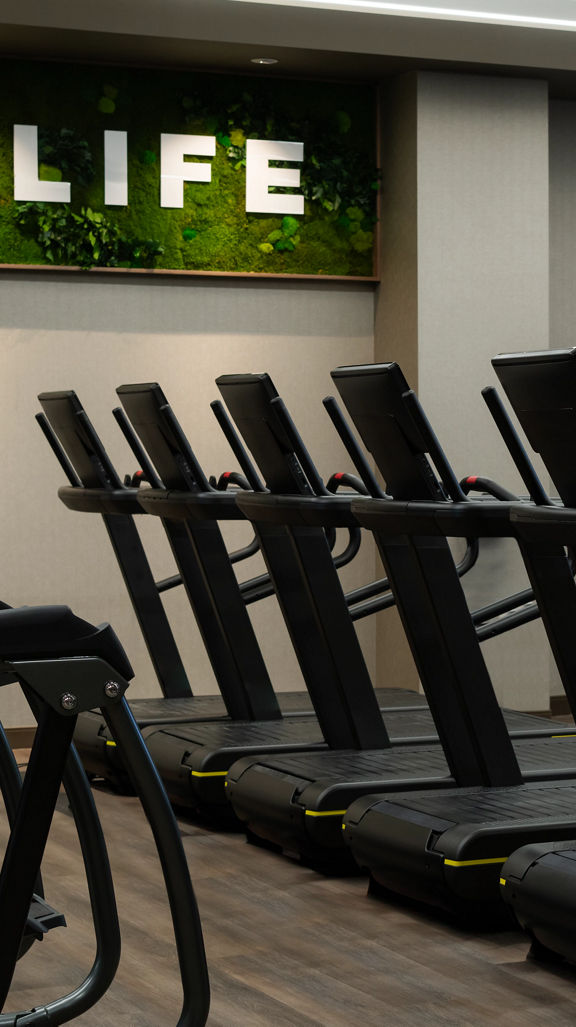 Row of treadmills on the fitness floor at the Life Time Atlantic Avenue club location