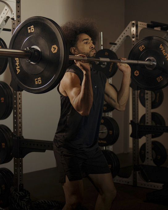 Alpha boutique group training class featuring a man lifting a barbell