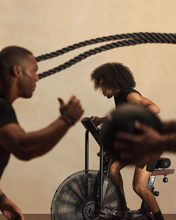 Alpha class instructor encouraging class member on stationary bike