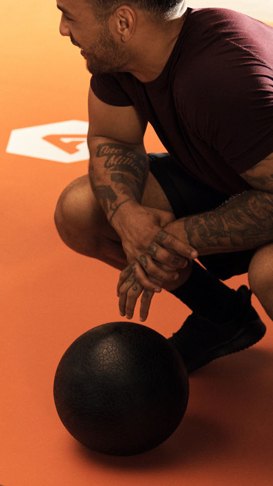 Alpha class member squatting next to a medicine ball