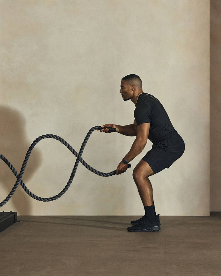 a man alternating battle ropes