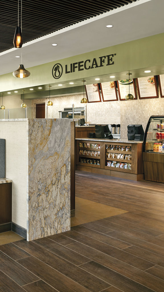 A gleaming wooden floor, tables with booths and chairs and the service counter in the LifeCafe at Life Time Ardmore