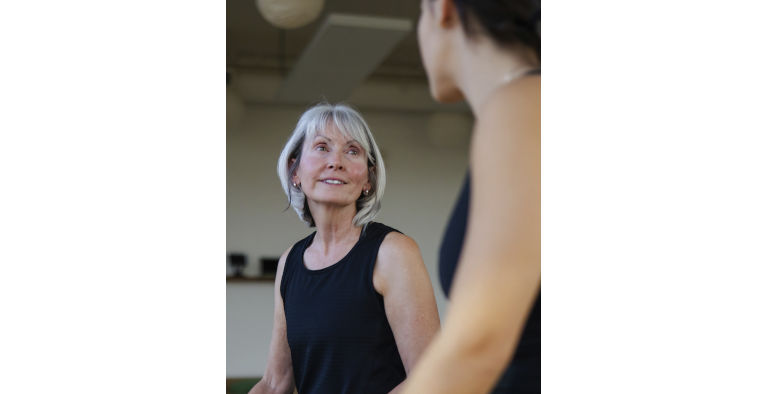 Two women chatting in a fitness room.
