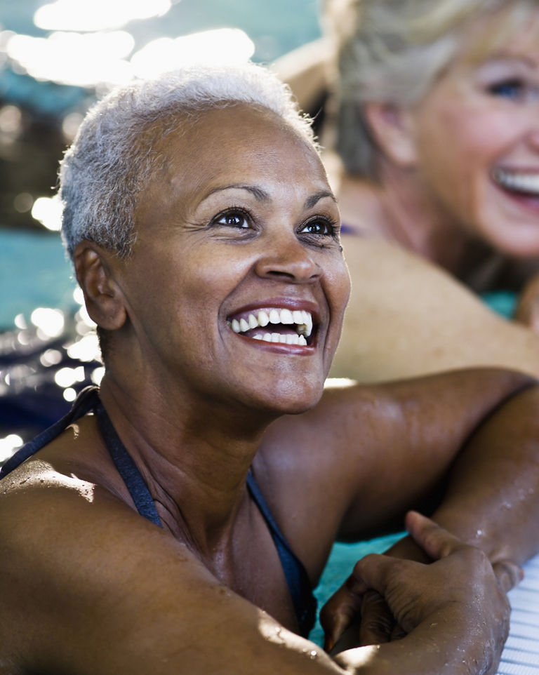 Close up of senior woman with friends (60s) at side of swimming pool