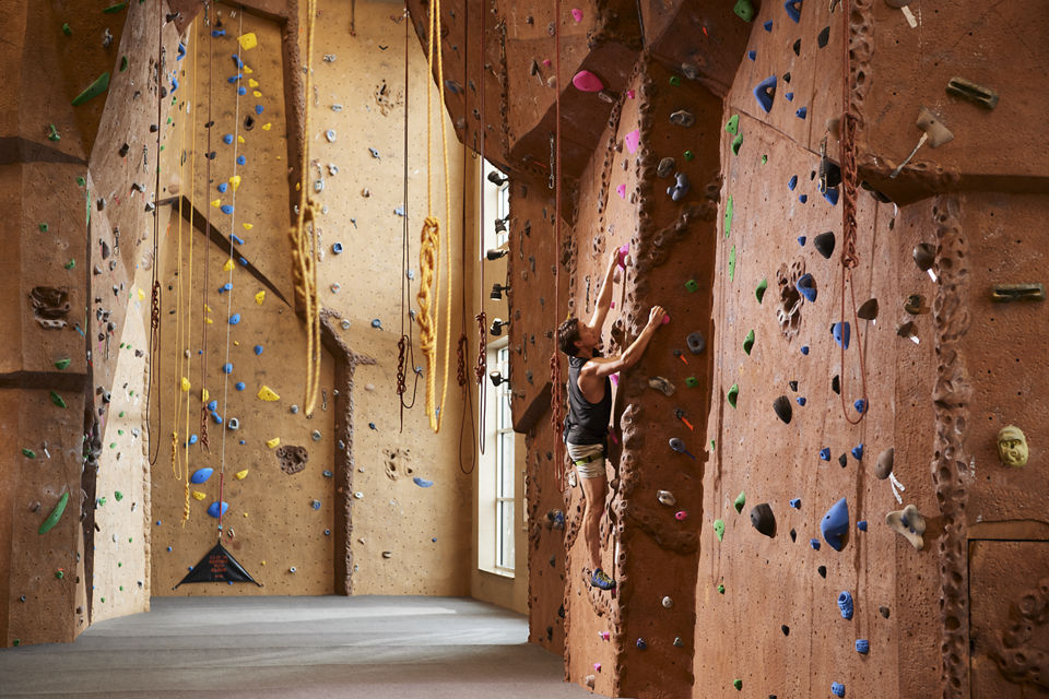 A man climbing and indoor climbing wall