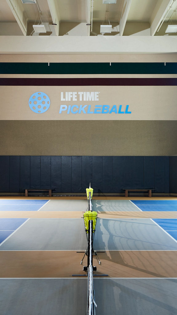 3 indoor pickleball courts in a brightly lit gymnasium