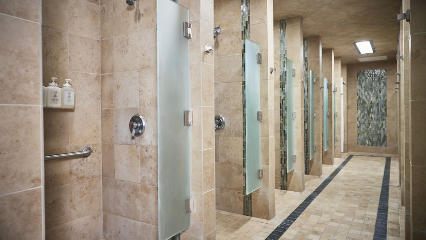 Row of shower stalls in a locker room at Life Time