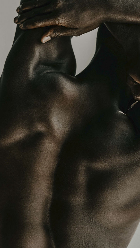 man crossing his arms above his head touching his back