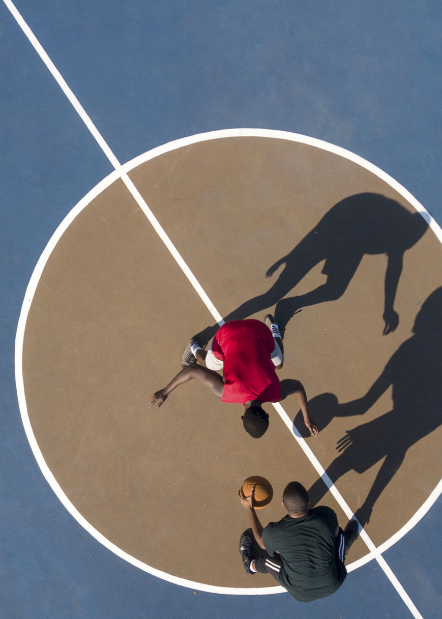 Aerial view of players on a blue and brown basketball court