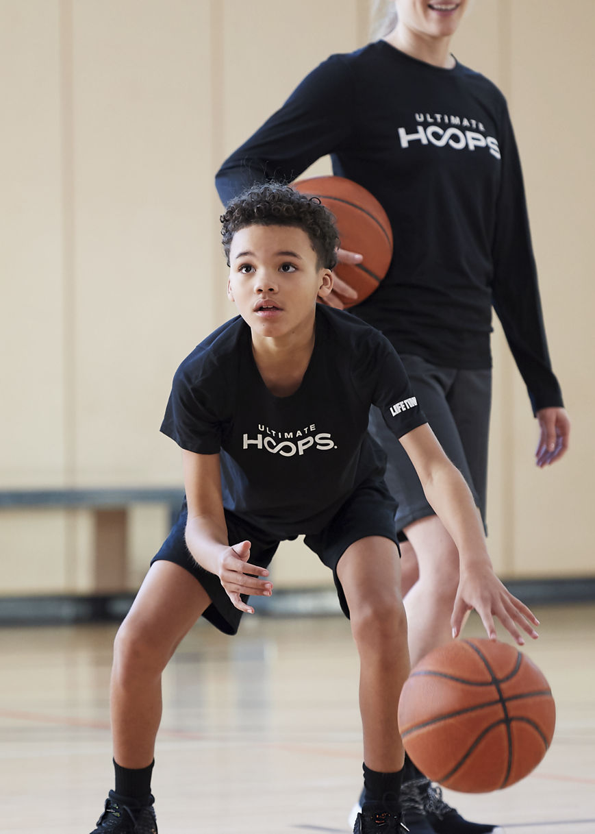 Two kids taking basketball lessons