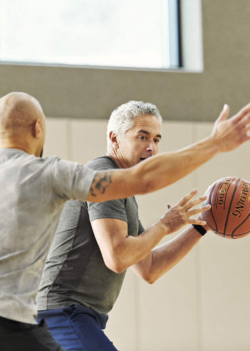 two males playing basketball - blocking/defense