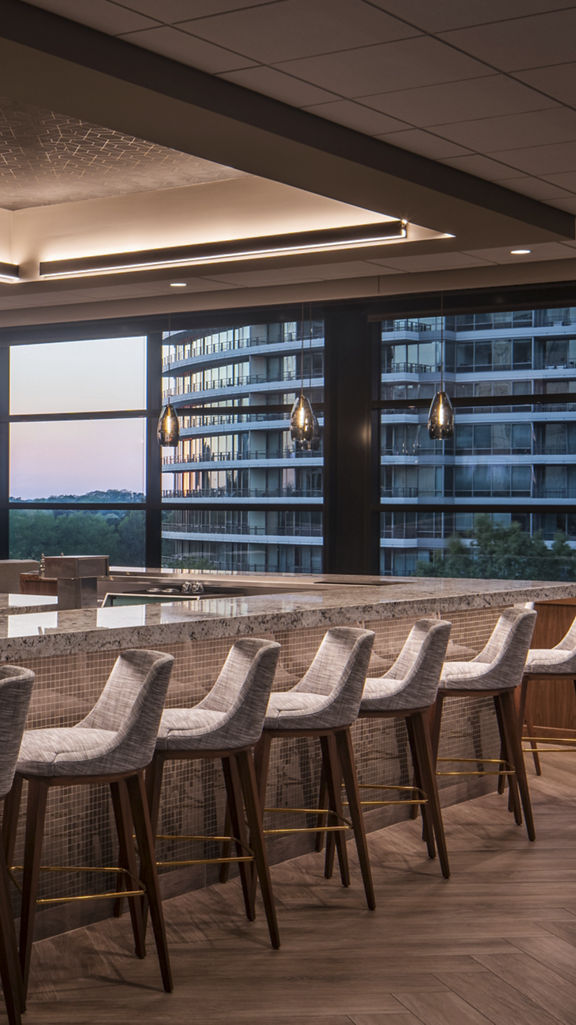 A bar with seating and lounge chairs and tables