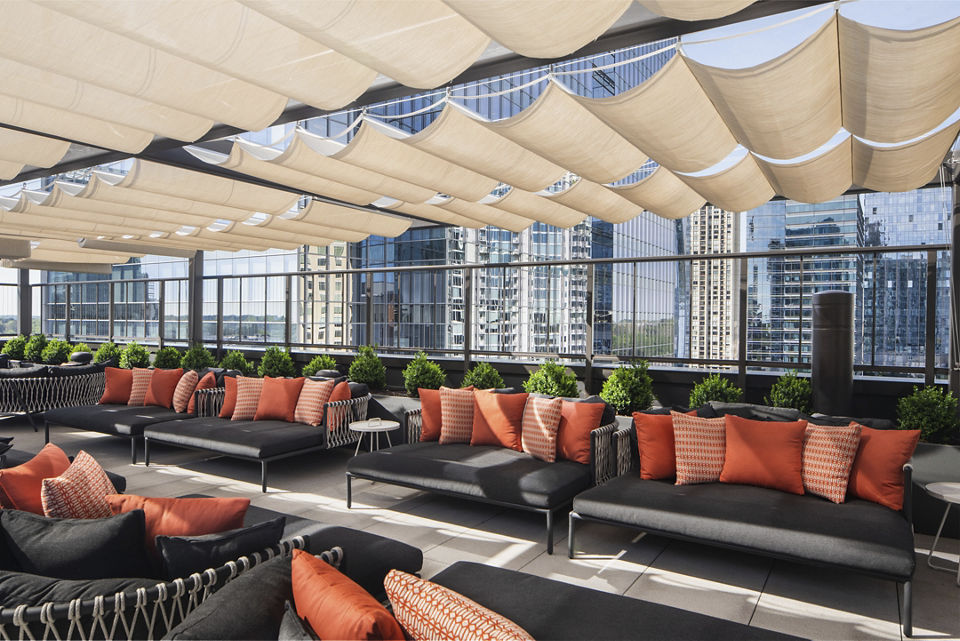 Outdoor loungers with shading overhead on a rooftop patio