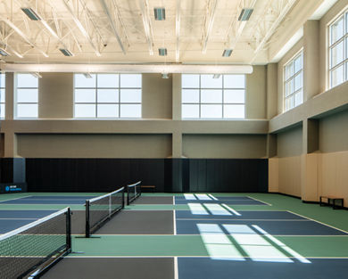 3 indoor pickleball courts in a brightly lit gymnasium