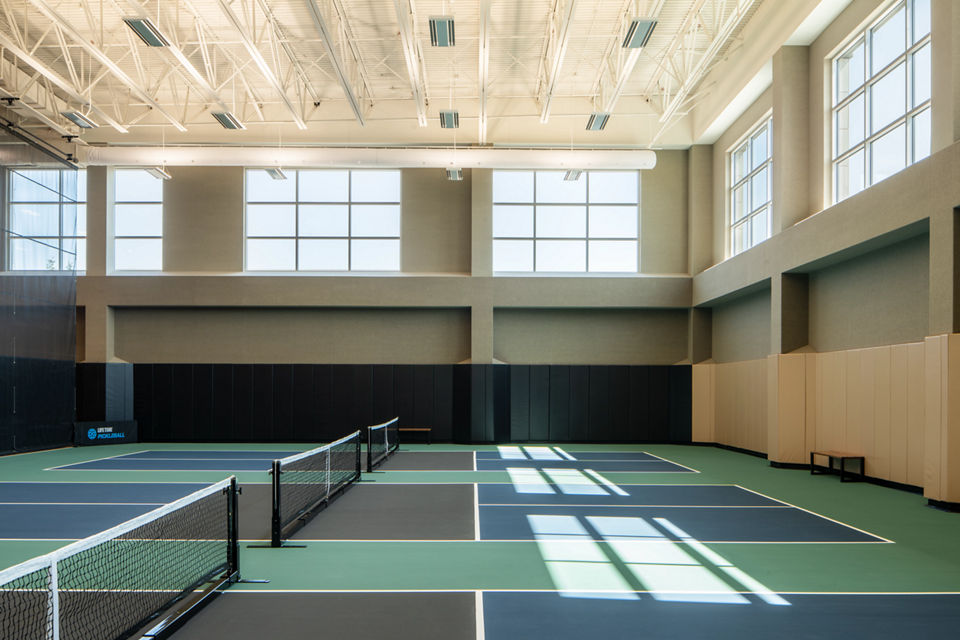 3 indoor pickleball courts in a brightly lit gymnasium