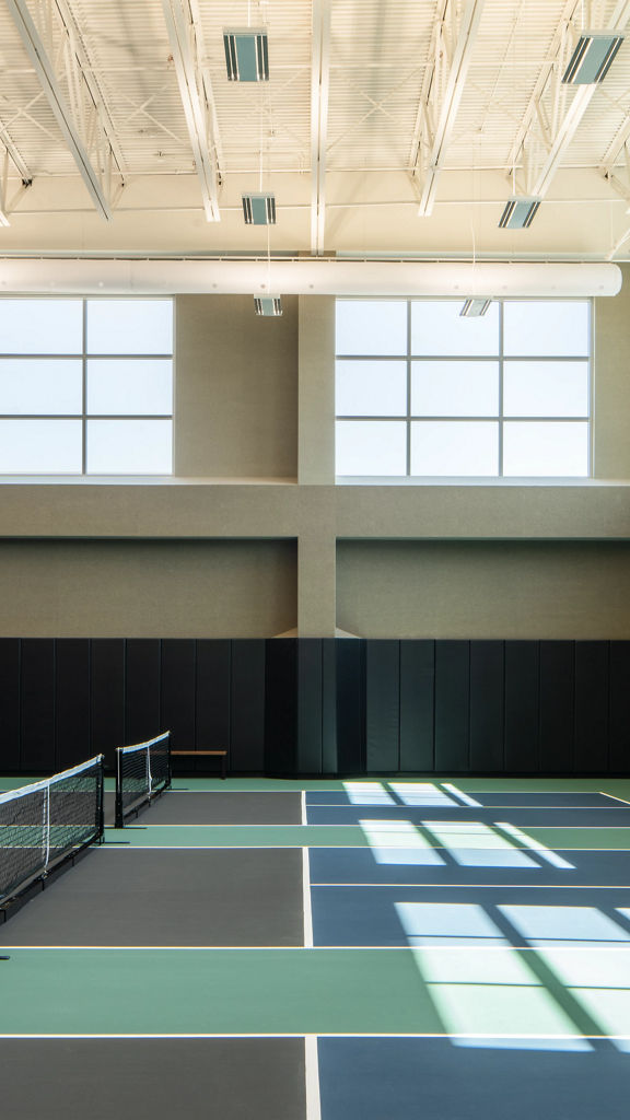 3 indoor pickleball courts in a brightly lit gymnasium