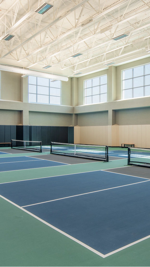 3 indoor pickleball courts in a brightly lit gymnasium