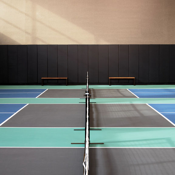 3 indoor pickleball courts with benches
