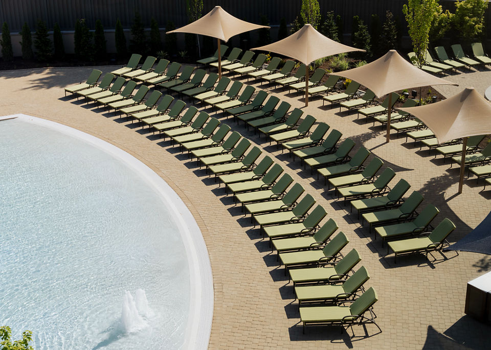 Pool lounge chairs lined up next to a zero-depth entry pool