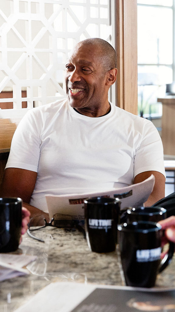 men sit around a table with coffee