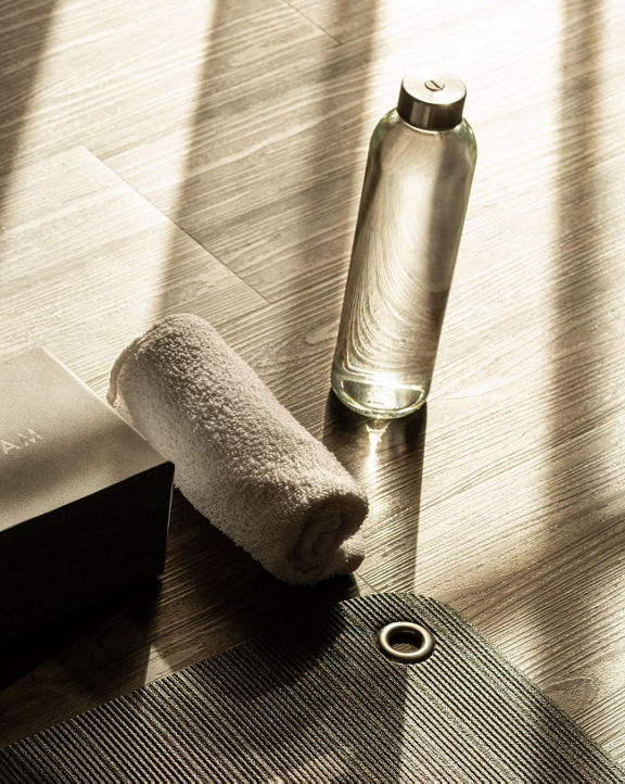 a yoga mat with a block, towel and water bottle
