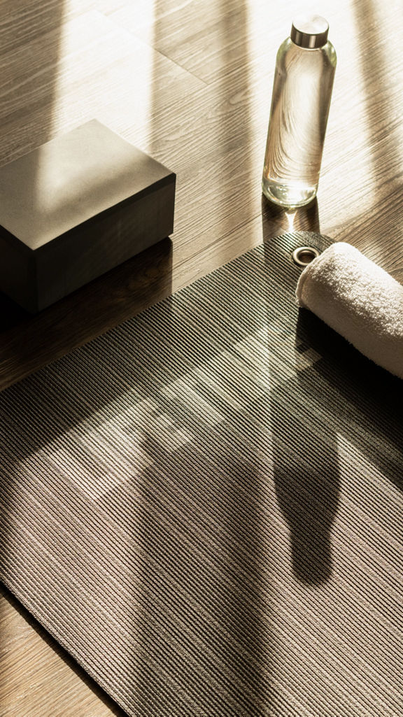 Sunlight shining onto a yoga mat, block, water bottle and towel in a yoga studio at Life Time