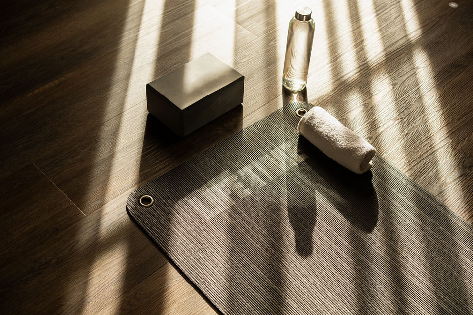 Sunlight shining onto a yoga mat, block, water bottle and towel in a yoga studio at Life Time