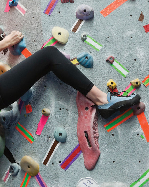 Woman climbing on climbing wall at gym
