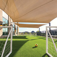 Two soccer goals stand next to each other with a soccer ball in between on an outdoor turf field