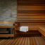 Inside a large sauna with wood paneling and a while towel draped over the bench