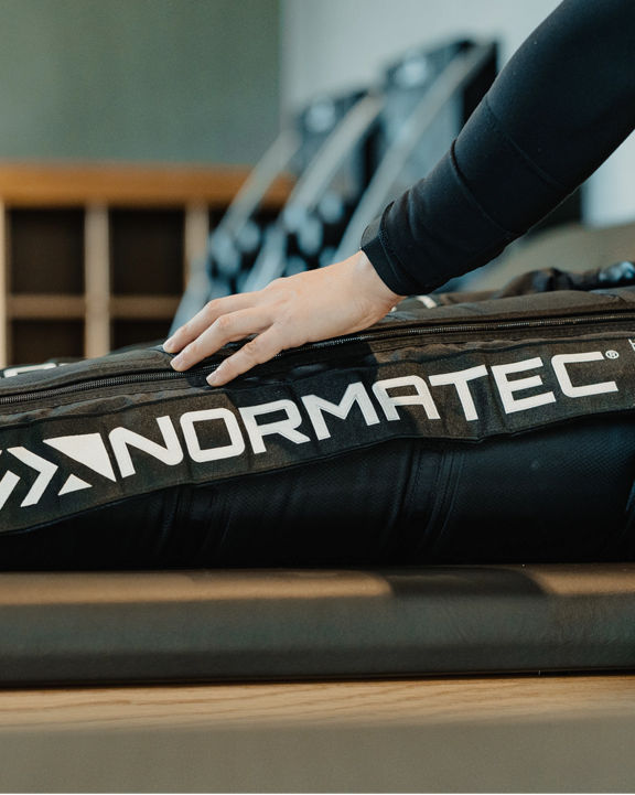 Close up of a Normatec boot on a member's leg during a dynamic stretch session at Life Time