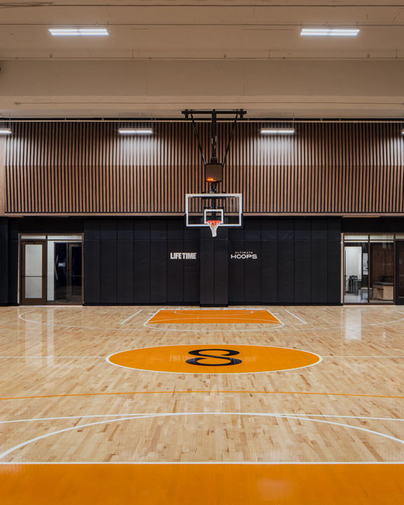 An indoor basketball court and gymnasium in New York with Uhoops branding