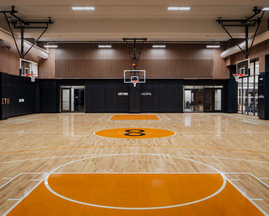 An indoor basketball court and gymnasium in New York with Uhoops branding