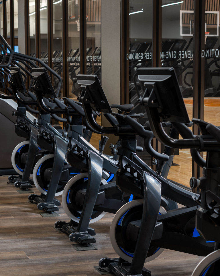 Stationary bikes and stairclimbers on the fitness floor at the Life Time Dumbo club location