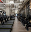 Stationary bikes, treadmills and stairclimbers on the fitness floor at the Life Time Dumbo club location