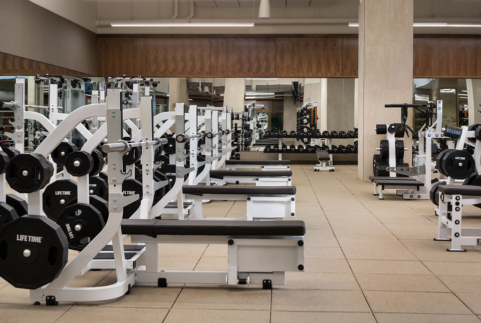 Weight benches and free weights on the fitness floor at Life Time