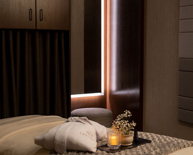 Serene massage room with a LifeSpa robe, candle and flowers atop a massage table