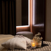 Serene massage room with a LifeSpa robe, candle and flowers atop a massage table
