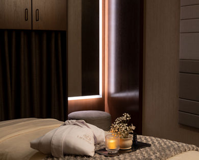 Serene massage room with a LifeSpa robe, candle and flowers atop a massage table