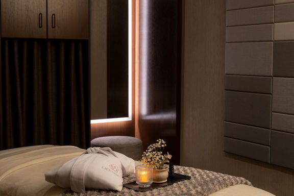 Serene massage room with a LifeSpa robe, candle and flowers atop a massage table