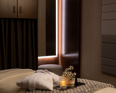 Serene massage room with a LifeSpa robe, candle and flowers atop a massage table
