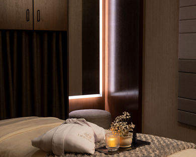 Serene massage room with a LifeSpa robe, candle and flowers atop a massage table
