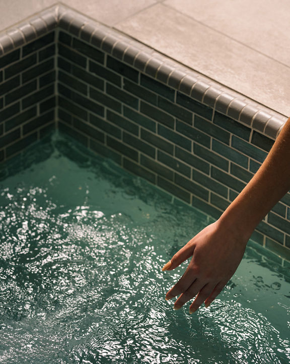 A female hand reaching into the water in a whirlpool