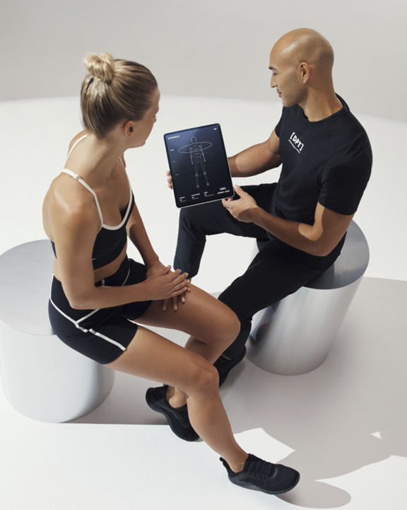 A Life Time Personal Trainer using an ipad during a consultation with a client