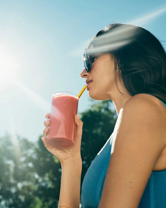 woman drinking a smoothie outside
