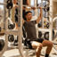 A man spotting another member while he completes overhead presses while seated on a weight bench