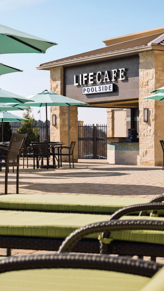 Tables, chairs, and umbrellas next to an outdoor pool