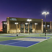3 outdoor pickleball courts outside a Life Time at dusk